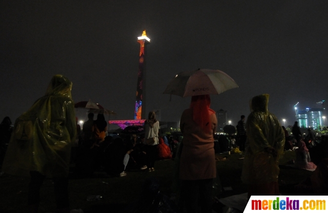 Foto Hujan Warga Tetap Antusias Saksikan Video Mapping Tahun Baru 2020 Di Monas Merdeka Com