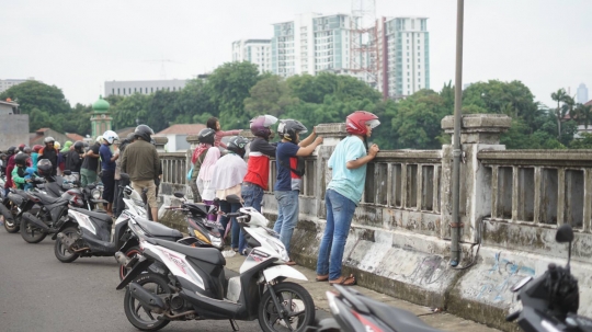 Banjir Ciliwung Jadi Tontonan Pemotor di Flyover Rawajati