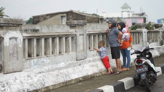 Banjir Ciliwung Jadi Tontonan Pemotor di Flyover Rawajati