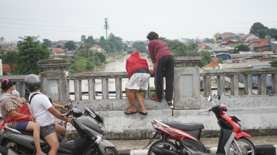 Banjir Ciliwung Jadi Tontonan Pemotor di Flyover Rawajati