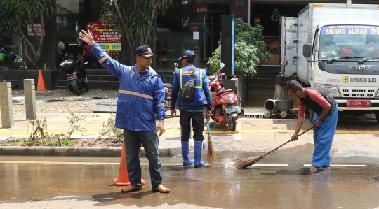 Petugas Bersihkan Sisa-Sisa Banjir di Kemang
