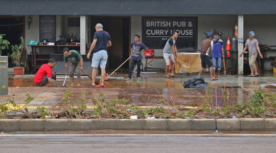Kesibukan Pekerja Bersihkan Bar yang Terendam Banjir di Kemang