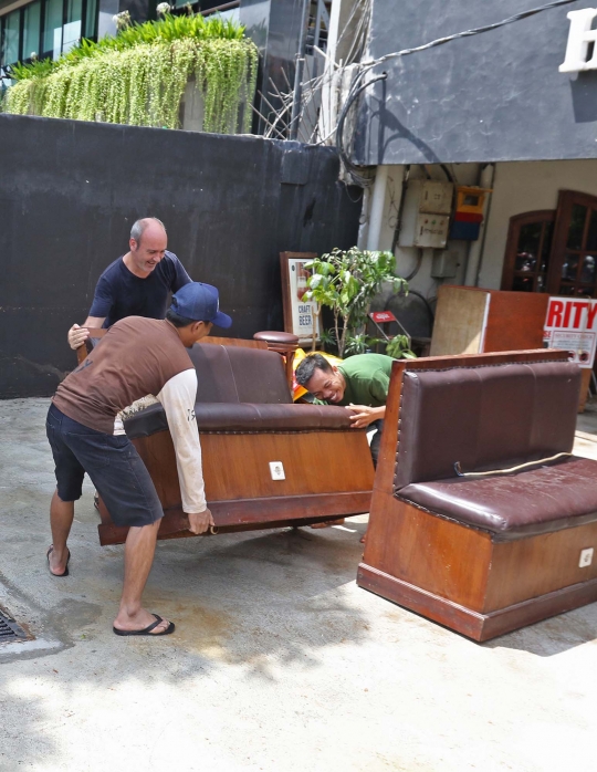 Kesibukan Pekerja Bersihkan Bar yang Terendam Banjir di Kemang