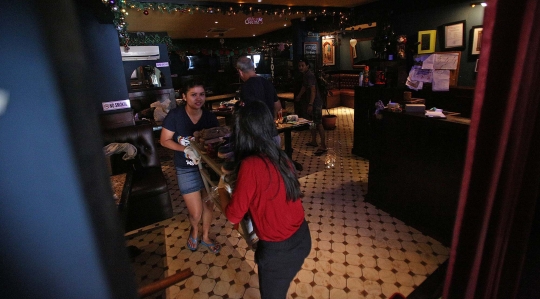 Kesibukan Pekerja Bersihkan Bar yang Terendam Banjir di Kemang