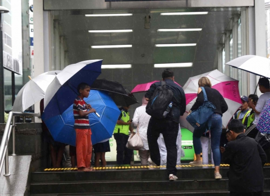 Hujan Jadi Berkah Ojek Payung di Bundaran HI