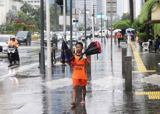 Hujan Jadi Berkah Ojek Payung di Bundaran HI