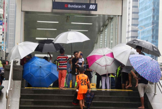 Hujan Jadi Berkah Ojek Payung di Bundaran HI
