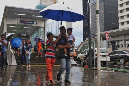 Hujan Jadi Berkah Ojek Payung di Bundaran HI