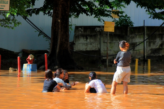 Anak-Anak Bermain di Tengah Banjir