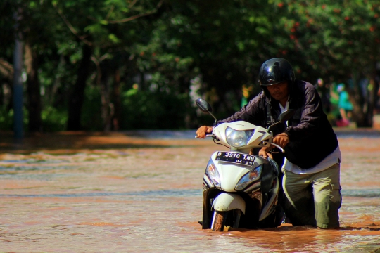 Pengendara Nekat Terjang Banjir di Jalan Kayu Putih