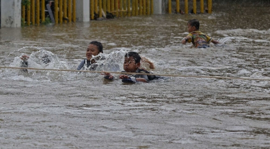 Saat Anak-anak Asyik Main Banjir di Jalan Raya Pondok Gede