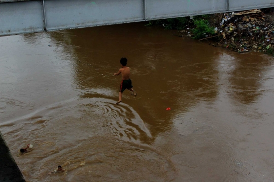 Aksi Nekat Bocah Loncat ke Kali Ciliwung yang Meluap Jadi Tontonan Warga