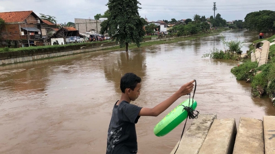 Petugas Gabungan Pantau Orang Hanyut di Sungai Ciliwung