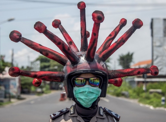Aksi Polisi Berhelm Corona Disinfektan Para Pengendara di Mojokerto