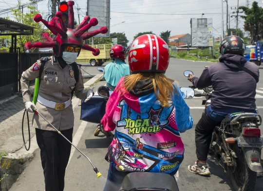Aksi Polisi Berhelm Corona Disinfektan Para Pengendara di Mojokerto