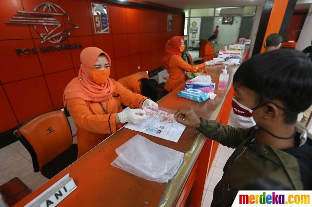 Warga mengambil bantuan sosial tunai Keluarga Penerima Manfaat (KPM) di Kantor Pos, Bogor, Jawa Barat, Rabu (13/5/2020).