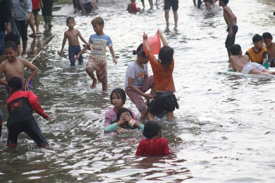 Wajah Ceria Anak-anak Bermain di Genangan Banjir Rob