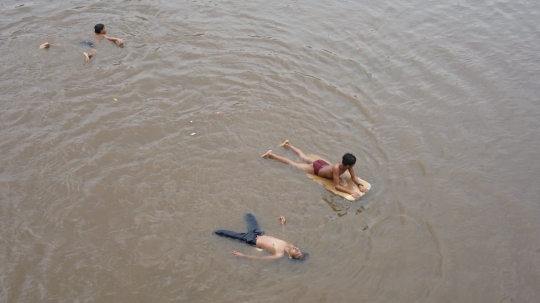 Potret Keceriaan Anak-Anak Bermain di Sungai Ciliwung