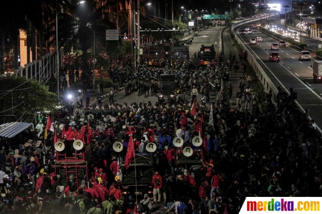 Mahasiswa dan elemen buruh bertahan hingga malam hari saat beraksi unjuk rasa di depan Gedung DPR/MPR/DPD, Jakarta, Kamis (16/7/2020).
