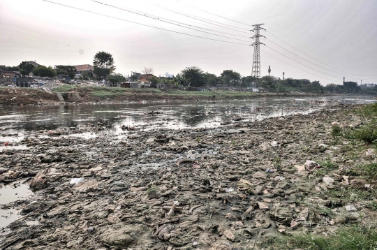 Kemarau, Tumpukan Sampah Muncul ke Permukaan Kanal Banjir Barat