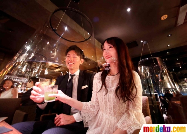 Kaca akrilik yang digunakan sebagai perisai menjaga jarak antar pengunjung terlihat diterapkan di sebuah klub malam Jazz Lounge Encounter di distrik Ginza di Tokyo, Jepang (6/8/2020).