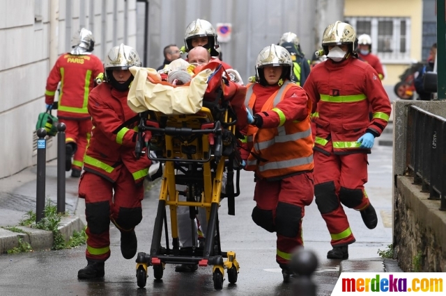 Petugas pemadam kebakaran mengevakuasi korban luka menyusul serangan penikaman oleh seorang pria di dekat bekas kantor majalah satir Charlie Hebdo di Paris, Prancis, pada 25 September 2020. Aksi penikaman brutal yang melukai empat orang, dua di antaranya terluka cukup parah.