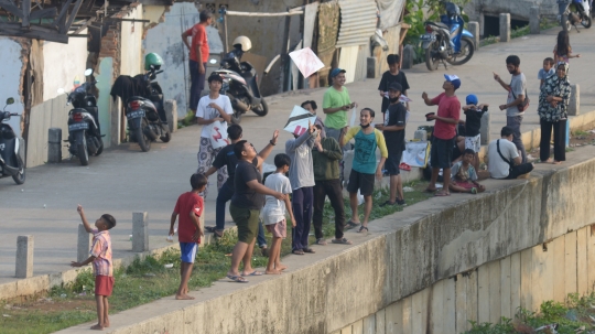 Ramainya Warga Bermain Layang-Layang di Pinggir Kali Ciliwung