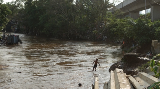 Kenekatan Anak-Anak Berenang di Tengah Aliran Deras Sungai Ciliwung