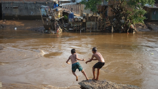 Kenekatan Anak-Anak Berenang di Tengah Aliran Deras Sungai Ciliwung
