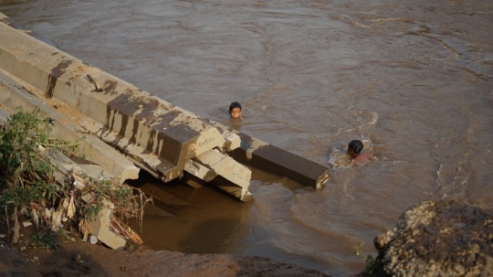 Kenekatan Anak-Anak Berenang di Tengah Aliran Deras Sungai Ciliwung