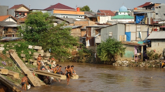 Kenekatan Anak-Anak Berenang di Tengah Aliran Deras Sungai Ciliwung
