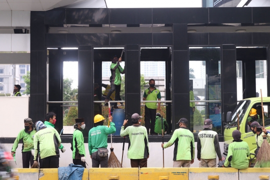 Petugas Bersihkan Sisa Kerusakan Halte Transjakarta