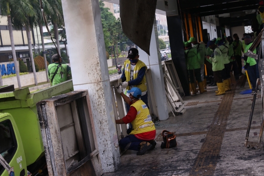 Petugas Bersihkan Sisa Kerusakan Halte Transjakarta