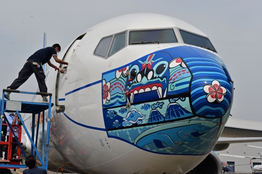 Wajah Pesawat Garuda Indonesia dengan Masker Bermotif Barong