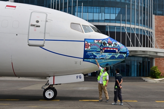 Wajah Pesawat Garuda Indonesia dengan Masker Bermotif Barong