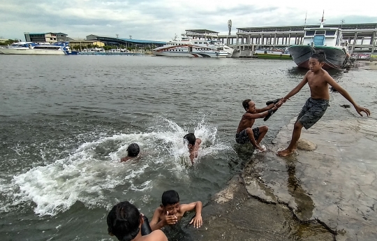 Keceriaan Anak Pesisir Berenang saat Banjir Rob di Pelabuhan Kali Adem