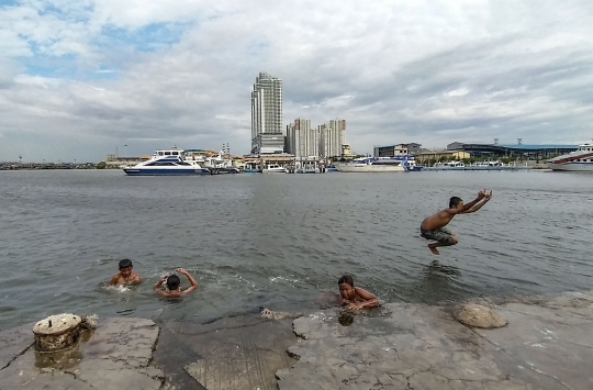 Keceriaan Anak Pesisir Berenang saat Banjir Rob di Pelabuhan Kali Adem