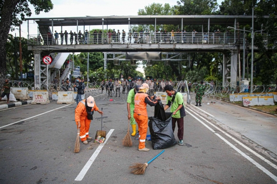 Aksi Petugas Bersihkan Sampah Massa Unjuk Rasa di Sekitaran Patung Kuda