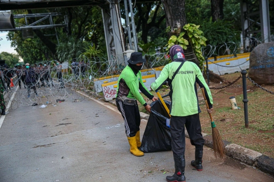 Aksi Petugas Bersihkan Sampah Massa Unjuk Rasa di Sekitaran Patung Kuda