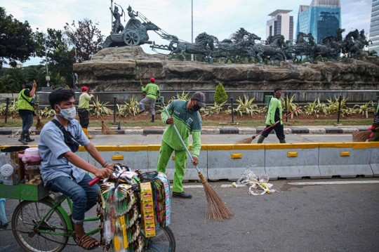 Aksi Petugas Bersihkan Sampah Massa Unjuk Rasa di Sekitaran Patung Kuda
