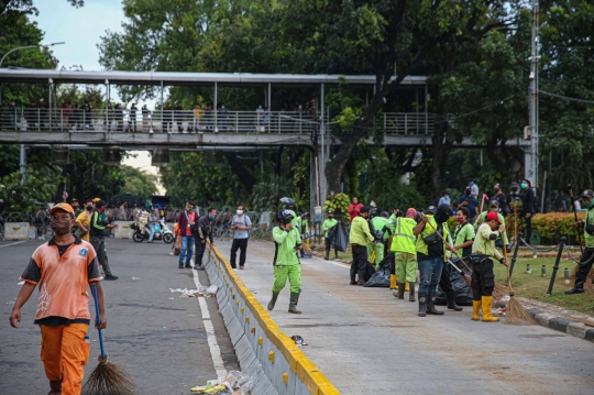 Aksi Petugas Bersihkan Sampah Massa Unjuk Rasa di Sekitaran Patung Kuda