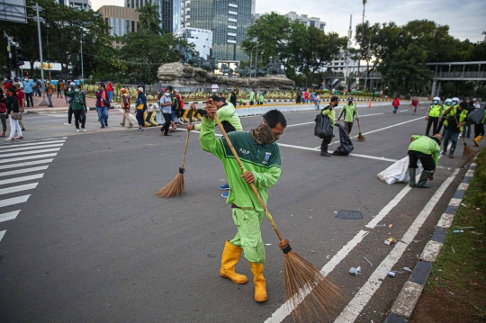 Aksi Petugas Bersihkan Sampah Massa Unjuk Rasa di Sekitaran Patung Kuda