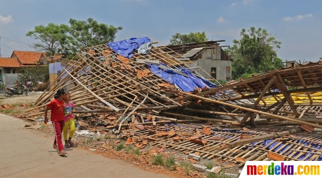 Anak-anak berjalan di dekat bangunan yang ambruk setelah diterjang angin puting beliung di Kaliabang Tengah, Kota Bekasi, Jawa Barat, Sabtu (24/10/2020). Menurut BPBD, sebanyak 159 rumah di Kelurahan Kaliabang Tengah mengalami kerusakan akibat terjangan angin puting beliung yang terjadi pada Jumat (23/10). Hingga kini pihak kelurahan dan BPBD terus mendata warga yang terdampak bencana tersebut.