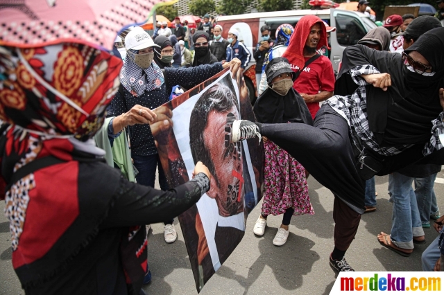 Pengunjuk rasa yang tergabung dalam gabungan elemen Islam menendang poster bergambar Presiden Prancis, Emmanuel Marcon saat menggelar aksi di kawasan Sarinah, Jakarta, Senin (2/11/2020).