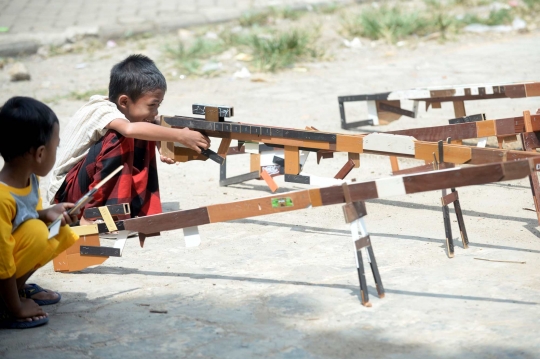 Keseruan Anak-Anak Bermain Tembak-tembakan dengan Mainan Tradisional