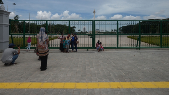 Belum Dibuka, Warga Berfoto di Balik Pagar Monas