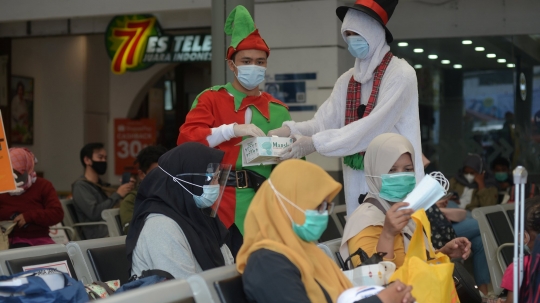 Berbaju Santa, Petugas KAI Bagikan Masker ke Penumpang