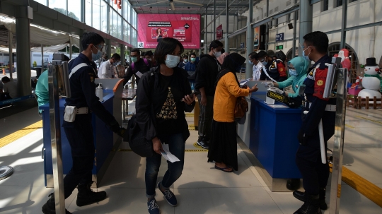 Berbaju Santa, Petugas KAI Bagikan Masker ke Penumpang