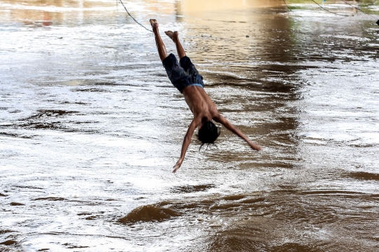 Aksi Nekat Anak-Anak Lompat ke Sungai Ciliwung yang Meluap