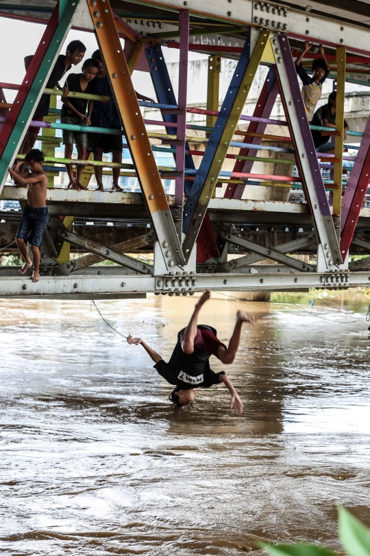 Aksi Nekat Anak-Anak Lompat ke Sungai Ciliwung yang Meluap